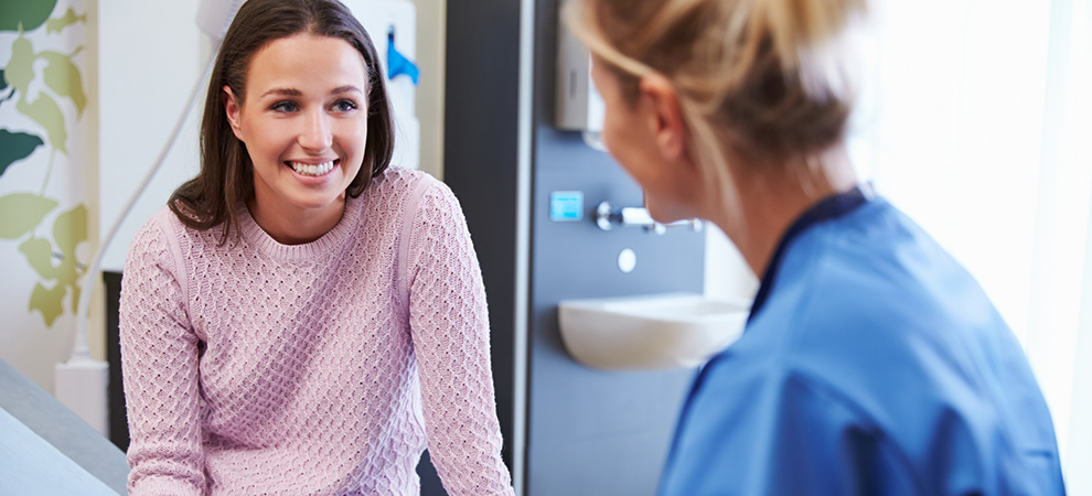 Female Patient And Nurse Have Consultation In Hospital Room