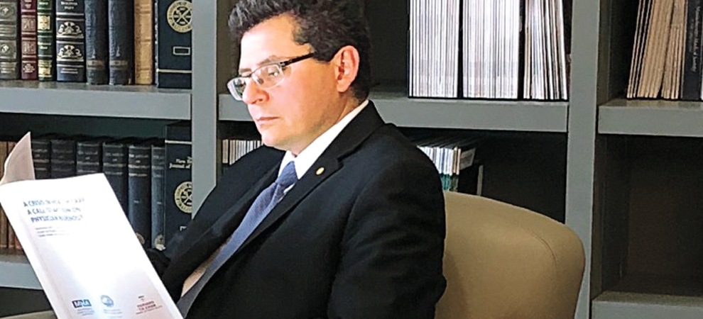 MMS President Alain Chaoui, MD, reviews the burnout report prior to a television interview
